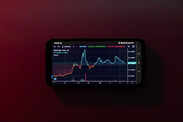 a-cell-phone-displaying-a-stock-chart-on-a-red-background