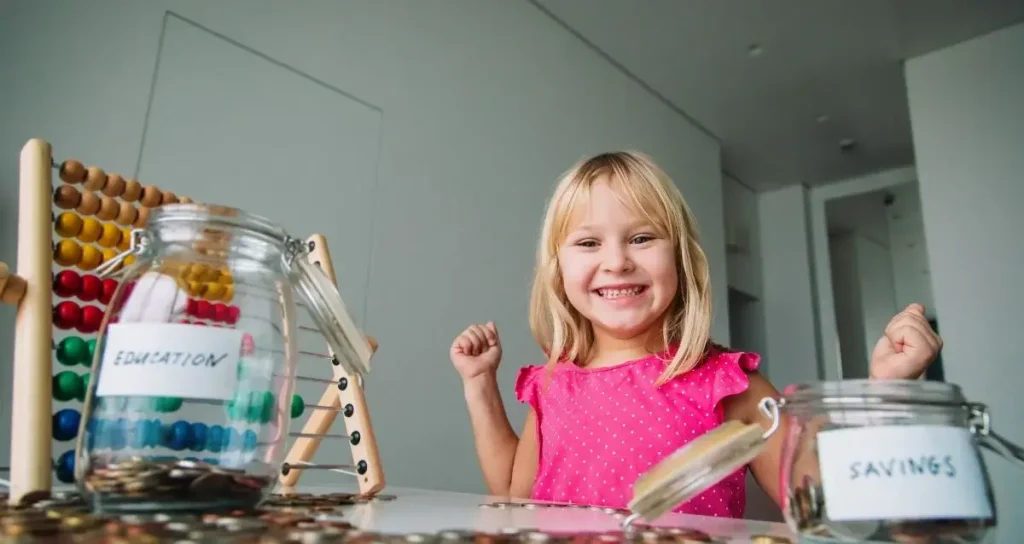Happy cute girl saving money, kid counting coins