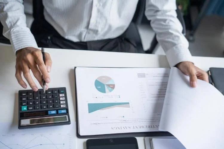 a person analyzing financial documents and charts related to retirement savings 